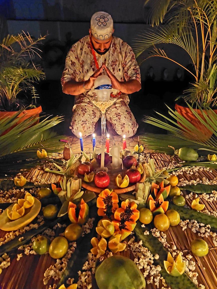 Pai Sebastian em ritual de amarração amorosa com oferendas, velas e frutas